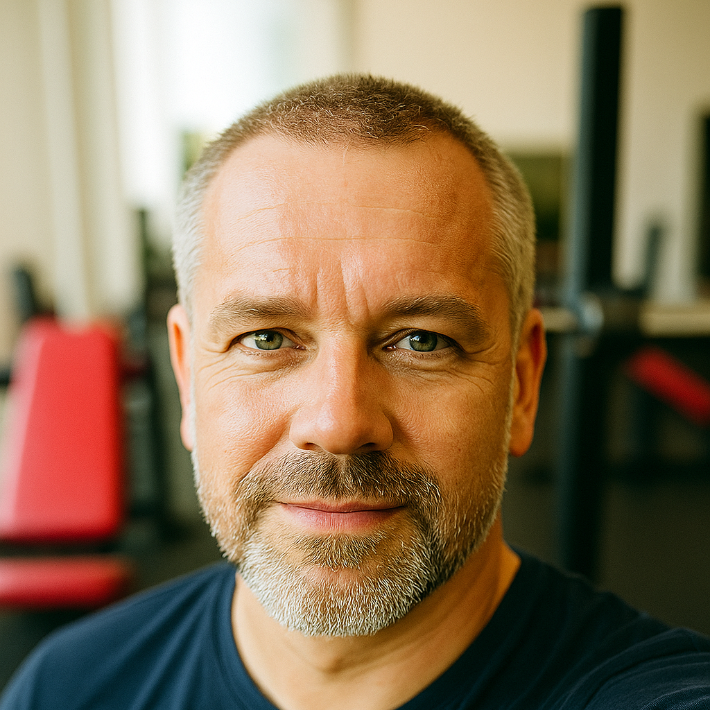 Sven D., 51 Jahre, Selfie im Fitnessstudio mit Hantelbank im unscharfen Hintergrund. Das sportliche Foto mit kräftigen Farben unterstreicht seine authentische Erfahrung mit der Testosterontherapie bei Remus Health.